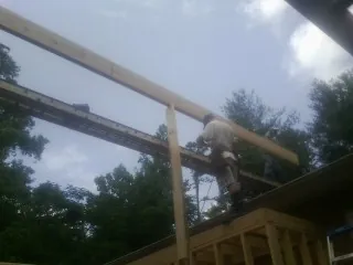 Carpenter setting a ridge beam over a new addition frame — Ice Dam Removal by Roofing Brothers in Herculaneum