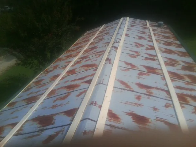 Rusted metal roof panels with new wood purlins before replacement — Storm Damage Roof Repair in Herculaneum by Roofing Brothers