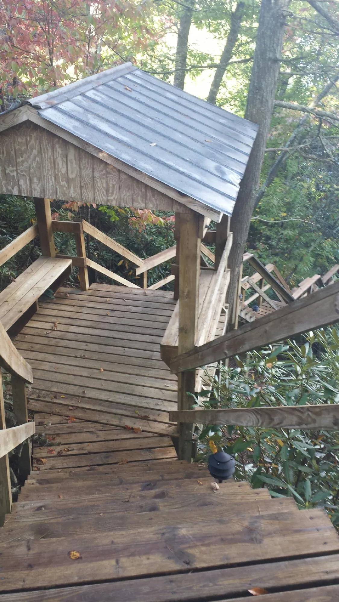 Metal roofed shelter over wooden steps on a wooded walkway — Skylight Repair & Installation work by our crew in Herculaneum