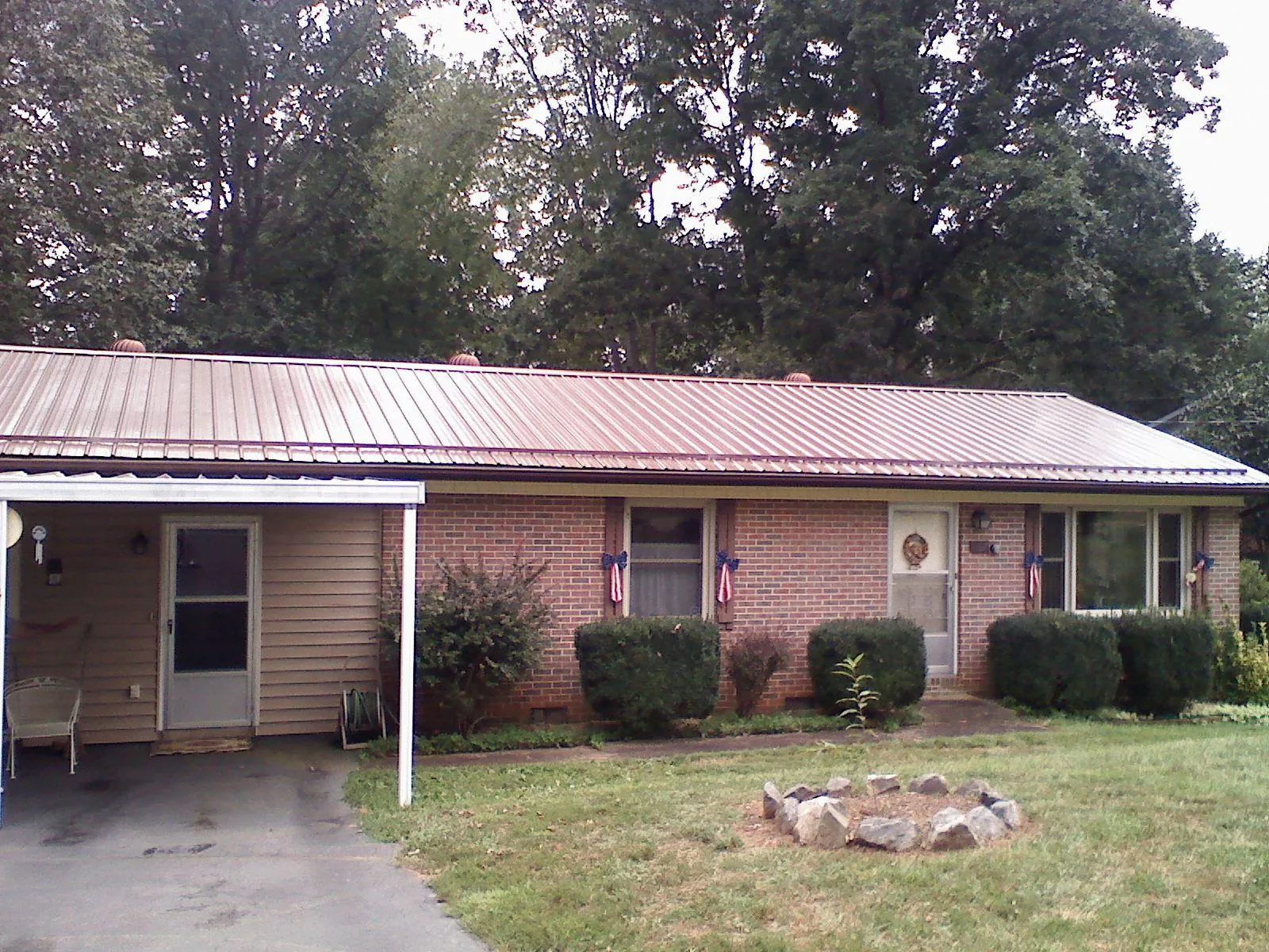 Bronze metal roof and carport on a brick ranch home — Roof Repair work by our crew in Herculaneum